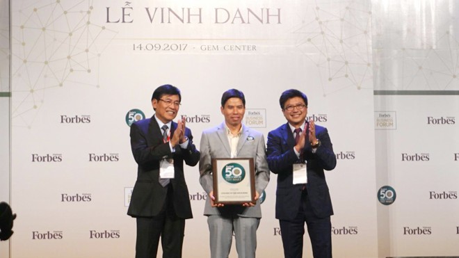 Ông Nguyễn Đức Tài, Chủ tịch HĐQT Thế Giới Di Động (người đứng giữa), nhận chứng nhận từ Forbes.