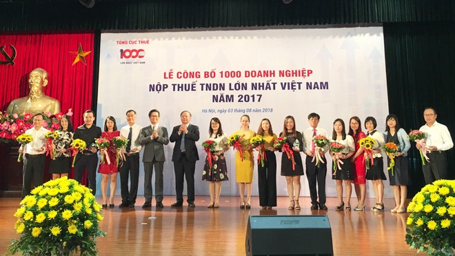Chủ tịch VCCI Vũ Tiến Lộc và Tổng cục trưởng Tổng cục Thuế Bùi Văn Nam trao kỷ niệm chương cho các doanh nghiệp Top 1000 doanh nghiệp nộp thuế thu nhập doanh nghiệp lớn nhất năm 2017. Ảnh: Tuấn Nguyễn