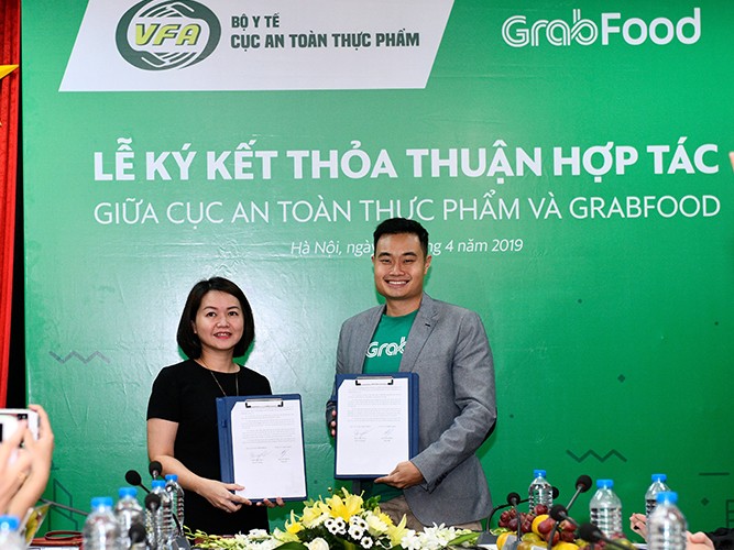 Bà Trần Việt Nga – Phó Cục trưởng Cục An toàn thực phẩm và ông erry Lim, Giám đốc Grab tại Việt Nam ký kết hợp tác.