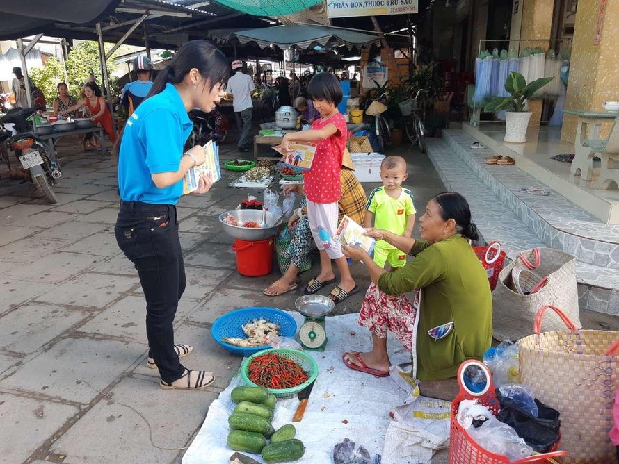 Cán bộ BHXH huyện Trà Cú (Trà Vinh) phát tờ rơi và tuyên truyền chính sách BHXH tự nguyện, BHYT hộ gia đình cho người dân tại các nhóm chợ