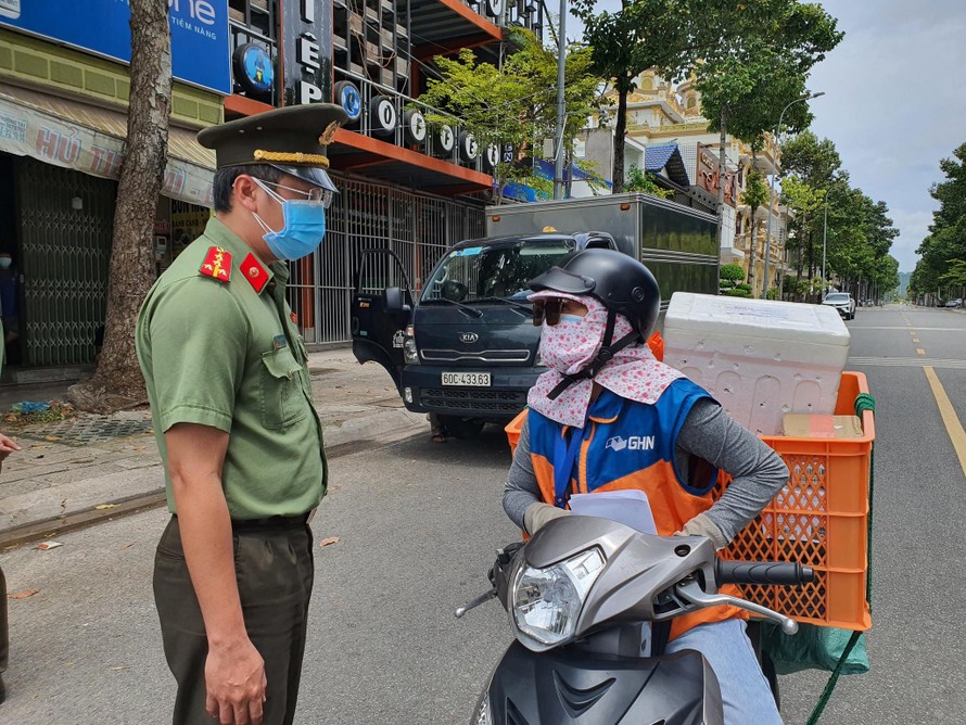 Lực lượng chức năng kiểm tra giấy tờ của của 1 người giao hàng tại Bà Rịa-Vũng Tàu. Ảnh: Nguyễn Long.