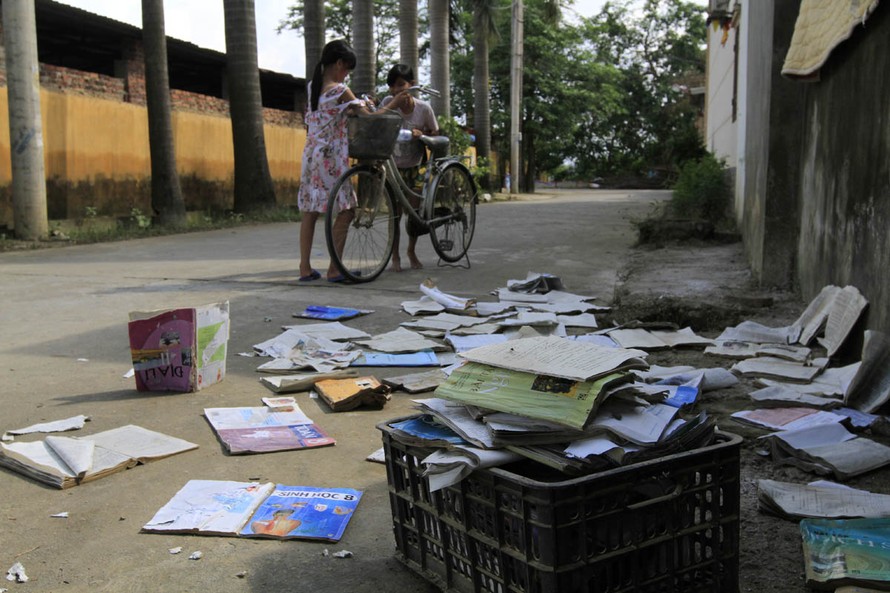 Học sinh ở thôn Bùi Xá (Thị trấn Xuân Mai, Chương Mỹ) phơi sách vở bị ngấm nước lũ. Ảnh: Trường Phong