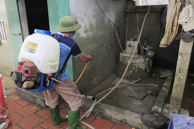 Một giếng nước bị ngập ở thôn Bùi Xá đang được bơm thuốc khử trùng. Ảnh: Trường Phong