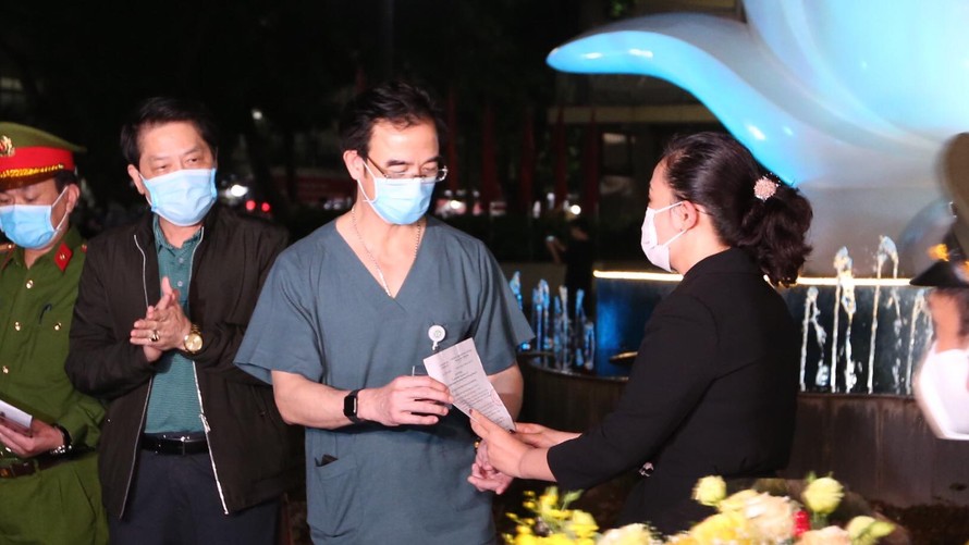 Giám đốc Bệnh viện Bạch Mai nhận quyết định hết cách ly phong tỏa từ lãnh đạo phường Phương Mai (quận Đống Đa) đêm 11/4. Ảnh: Hoàng Mạnh Thắng