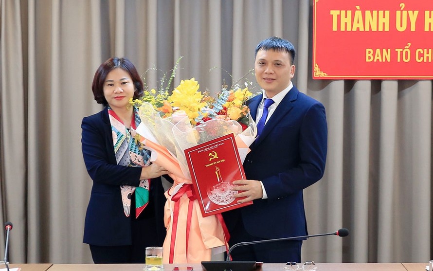 Phó Bí thư Thường trực Thành ủy Hà Nội Nguyễn Thị Tuyến trao quyết định của Ban Thường vụ Thành ủy và tặng hoa chúc mừng ông Nguyễn Minh Long
