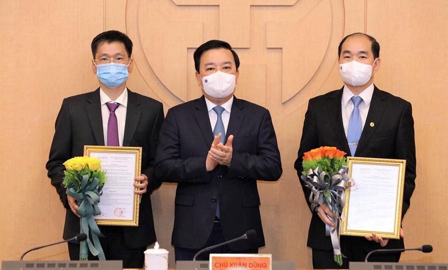 Phó Chủ tịch UBND thành phố Hà Nội Chử Xuân Dũng trao quyết định, tặng hoa chúc mừng hai Phó Giám đốc Sở Y tế Hà Nội