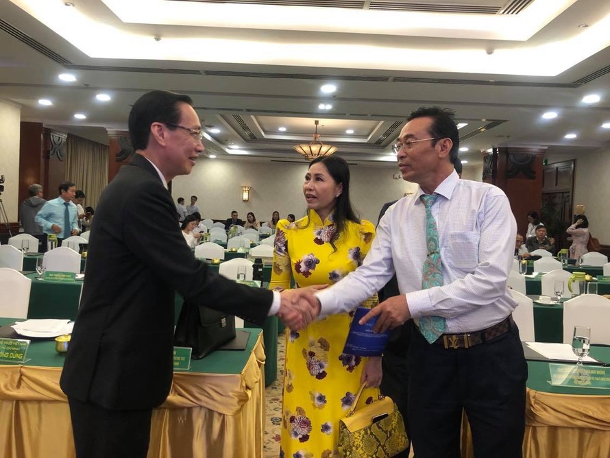 Phó chủ tịch Thường trực UBND TPHCM Lê Thanh Liêm (trái) trò chuyện cùng kiều bào