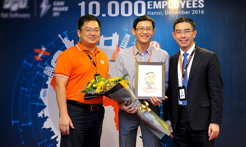 Chủ tịch FPT Software Hoàng Nam Tiến (trái) chúc mừng Lâm Thái Sơn - nhân viên thứ 10.000 Ảnh: Xuân Tùng