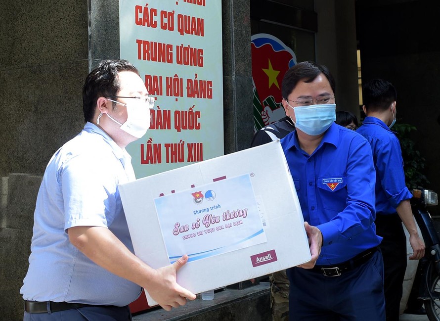 Anh Nguyễn Anh Tuấn và các đoàn viên thanh niên chuyển các thùng quà lên xe đến với các vùng dịch. Ảnh: Xuân Tùng