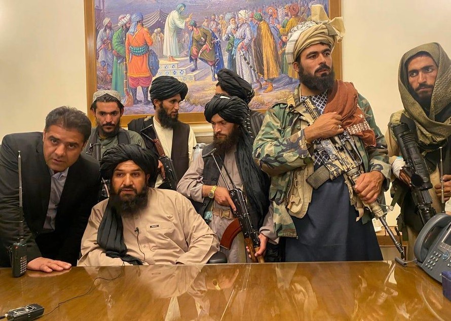 Các chiến binh Taliban ngồi vào bàn làm việc của Tổng thống Afghanistan Ashraf Ghani, người đã bỏ trốn khỏi đất nước hôm 15/8 chỉ vài giờ trước đó.