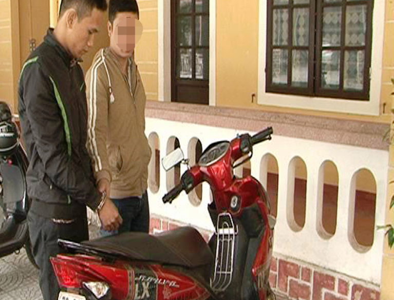 “Siêu trộm” Trần Thanh Đạt (bìa trái) cùng tang vật là chiếc xe gắn máy Nouvo LX có gắn thiết bị định vị. Ảnh: T.Bình.