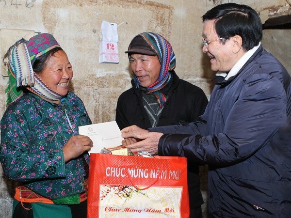 Chủ tịch nước Trương Tấn Sang đến thăm, chúc Tết và tặng quà cho gia đình bà Vừ Thị Máy, thương binh nặng ở xã Lũng Cú, huyện Đồng Văn, tỉnh Hà Giang. (Ảnh: Nguyễn Khang/TTXVN)