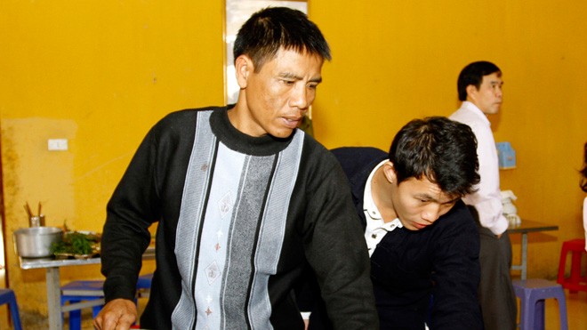 Anh Vương (ngoài cùng bên trái) chuẩn bị bữa cơm khi đồn có khách. ảnh: Xuân Tùng