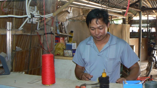Anh Nguyễn Văn An đang sửa máy đan len. ẢNH: TÙNG HUYÊN
