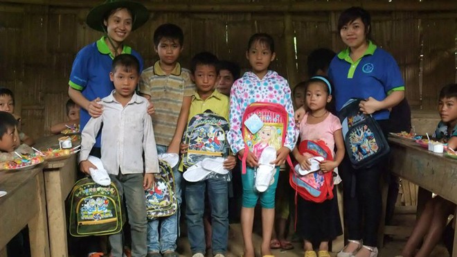 Sinh viên tình nguyện tặng quà và chăm sóc trẻ em có hoàn cảnh khó khăn miền núi Hà Giang. Ảnh: Thùy Trang