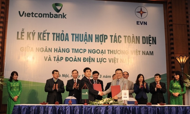 Đại diện Vietcombank, ông Nghiêm Xuân Thành, Ủy viên HĐQT kiêm Tổng Giám đốc (hàng đầu, bên trái) và Đại diện EVN, ông Phạm Lê Thanh, Tổng Giám đốc ký kết thỏa thuận hợp tác toàn diện giữa hai bên