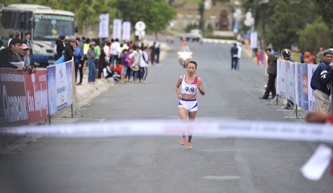 Phạm Thị Bình đánh đích đầu tiên ở nội dung marathon của nữ với đôi chân trần quen thuộc. Ảnh Hoàng Anh.