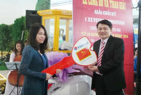 Đại diện Công ty Vietravel trao tặng xe máy cho khách hàng Dương Thị Ánh Nguyệt. 