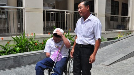 Thí sinh Hồ Văn Lai, được người cha đẩy xe lăn đưa đi thi ĐH. Ảnh: VTC News 