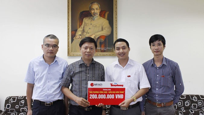 Ông Nguyễn Minh Tâm (thứ hai từ phải sang), Giám đốc Kinh doanh Elmich Việt Nam trao biểu trưng số tiền ủng hộ cho Phó TBT Báo Tiền Phong Trần Thanh Lâm