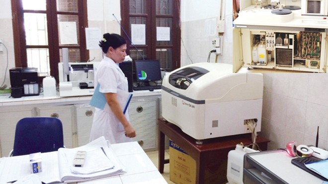 Chiếc máy bị tịch thu (ảnh nhỏ), máy xét nghiệm được cấp theo gói thầu số 4 tại bệnh viện đa khoa Thường Tín (ảnh lớn). Ảnh: Thái Hà - Nguyễn Tú
