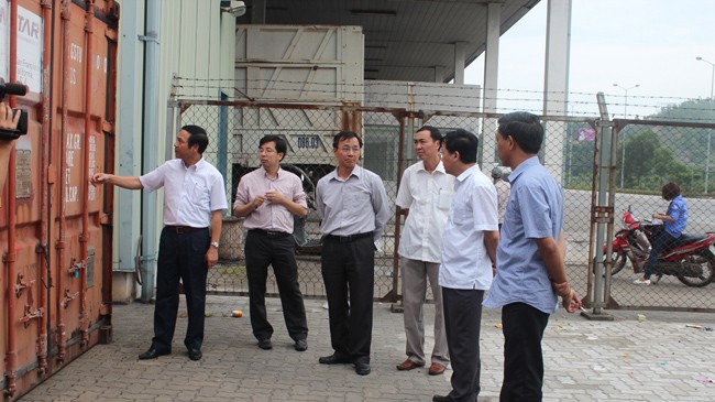Phó Chủ tịch UBND tỉnh Quảng Ninh Đặng Huy Hậu (ngoài cùng bên trái) tại hiện trường lưu giữ hai container chứa dầu biến thế nhiễm PCB tại cảng Cái Lân. Ảnh: Đỗ Hoàng