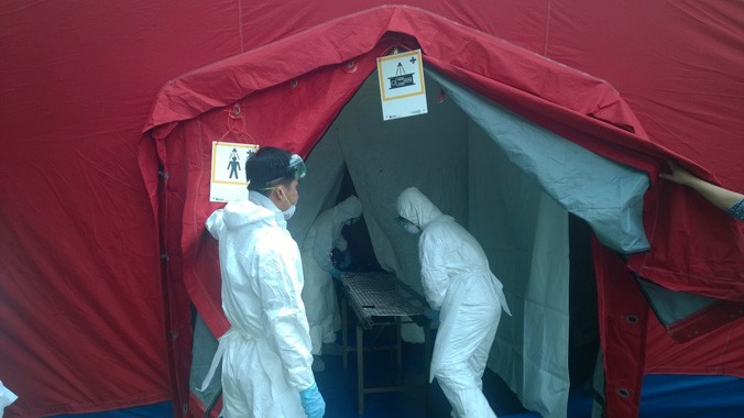 Bệnh nhân bị sốt được cách ly khử khuẩn tại sân bay trước khi đưa về BV Bệnh Nhiệt đới TPHCM. Ảnh: L.N