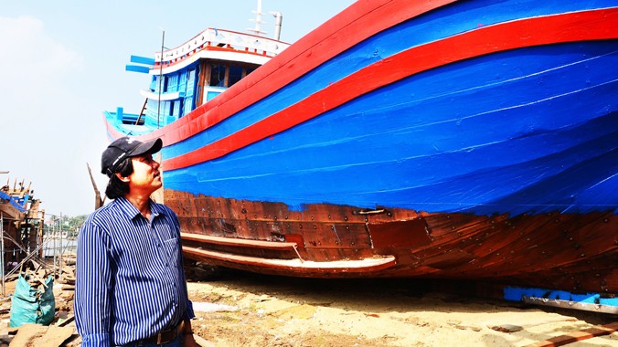 Ông Nguyễn Tấn Hùng giới thiệu tàu dài tới 25 mét tại bãi đà của mình ở thôn Phổ Trung, xã Nghĩa An. Ảnh: Hà Anh 