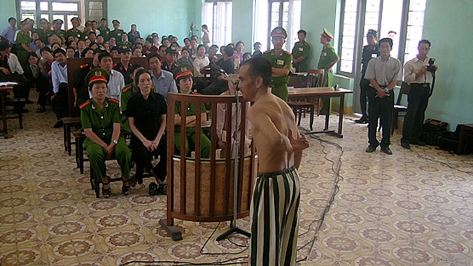 Ông Huỳnh Văn Nén cởi áo, chỉ những vết sẹo mà ông nói là do bị đánh trong tù, tại phiên tòa phúc thẩm (lần 3) “Vụ án vườn điều” ngày 9/3/2005. Ảnh: Nguyễn Đình Quân 