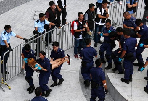  Cảnh sát Hồng Kông khiêng từng sinh viên ra khỏi trụ sở chính quyền - Ảnh: Reuters 