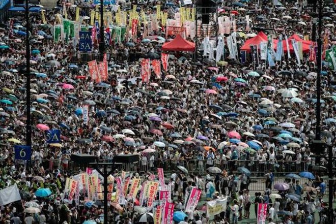 Nhiều người Hong Kong mang theo ô khi biểu tình để vừa che nắng vừa chống bị cảnh sát xịt hơi cay. Ảnh: Philippe Lopez