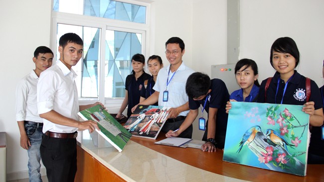Giảng viên Hồ Dương Đông (đeo kính) cùng sinh viên khoa Quản lý dự án - ĐH Bách khoa Đà Nẵng tiếp nhận tranh, ảnh tại Bệnh viện Ung thư Đà Nẵng.