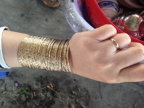 Hình chụp cô gái ăn bún riêu tại chợ Mỹ Hội, Cao Lãnh, Đồng Tháp tháng 2/2014. Cô này đeo 6 bộ vòng, tất cả 42 chiếc, tương đương 2 cây vàng. Ảnh: Văn Bảy (Thể Thao Văn Hóa)
