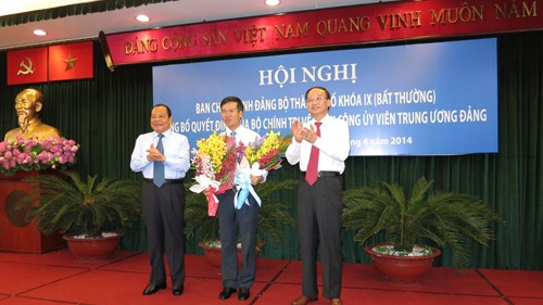 Ông Võ Văn Thưởng (giữa) nhận quyết định từ ông Tô Huy Rứa (phải) và hoa chúc mừng của ông Lê Thanh Hải (trái) - Ảnh: Nguyên Mi (Thanh Niên)