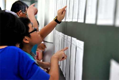  Học sinh kiểm tra số báo danh và phòng thi trong kì thi tuyển vào lớp 6 tại trường THCS Nguyễn Tất Thành. Ảnh: Quý Đoàn (VnExpress).