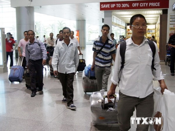  Nhóm công nhân lao động Việt Nam về đến sân bay Tân Sơn Nhất. (Ảnh: Hoàng Hải/TTXVN) 