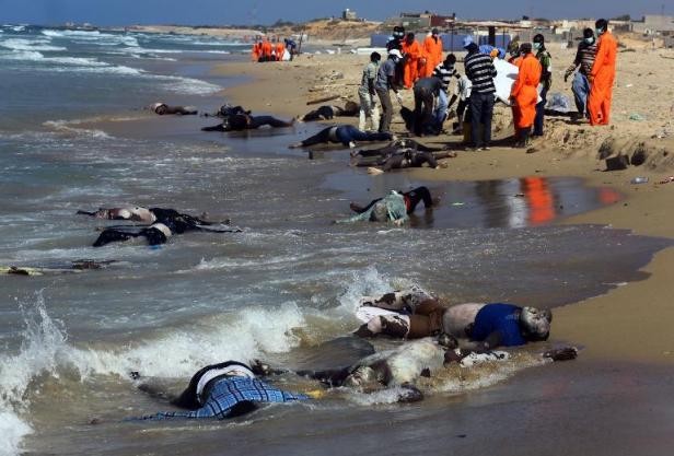Các nhân viên cứu hộ đang thu thập thi thể những người nhập cư trái phép trên bãi biển Al-Qarbole, cách Tripoli 60km về phía Đông. Ảnh: AFP