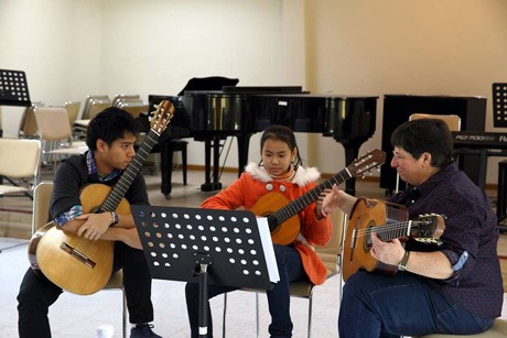 Trần Tuấn An (trái) và giáo sư ĐH North Park (phải) có buổi truyền dạy kiến thức cho học sinh khoa guitar tại Học viện Âm nhạc quốc gia Việt Nam. Ảnh: Dân Trí