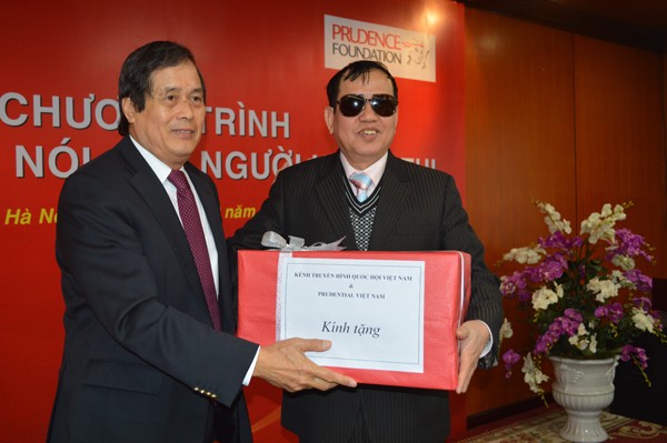 Ông Trần Quang Hoan, thành viên Hội đồng Thành viên Cty Prudential Việt Nam (trái) trao tặng sách nói cho ông Cao Văn Thành, Chủ tịch Hội Người mù Việt Nam. Ảnh: K.N 