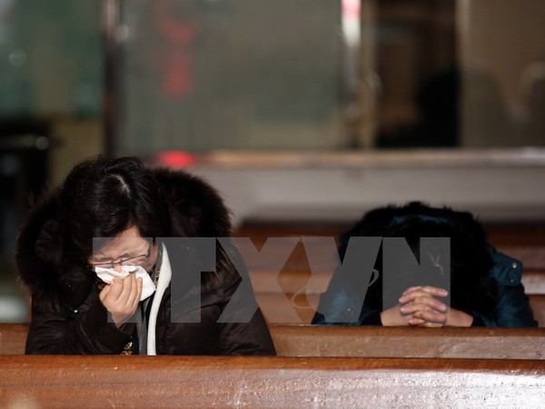 Thân nhân các hành khách trên máy bay mất tích QZ8501 cầu nguyện tại một nhà thờ ở thành phố cảng Yeosu, miền nam Hàn Quốc ngày 28/12. Ảnh: AFP/TTXVN. 