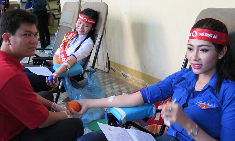 Người đẹp áo dài Hoa hậu Việt Nam 2014 Nguyễn Huỳnh Trúc Mai (áo trắng) và Hoa hậu Đại Dương 2014 Đặng Thu Thảo tham gia hiến máu.