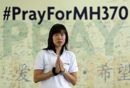 Một phụ nữ ở ngoại ô Kuala Lumpur cầu nguyện cho những người mất tích trên chuyến bay MH370. Ảnh: Reuters