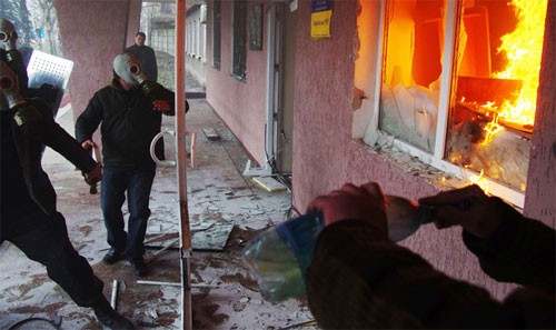 Những người biểu tình mang mặt nạ chống độc và bom xăng tấn công vào tòa nhà của lực lượng an ninh ở thành phố miền đông Gorlovka hôm qua. Ảnh: Reuters