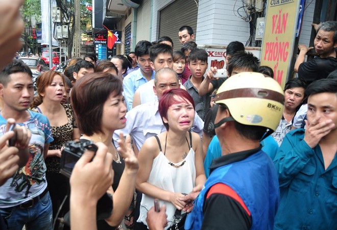Hân (áo trắng) cùng một nữ nhân viên gào khóc gọi tên đồng nghiệp trước cổng quán karaoke bị cháy,