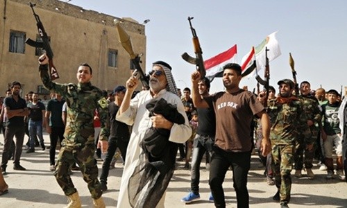 Những tình nguyện viên tham gia cuộc chiến chống phiến quân dòng Sunni mang vũ khí trong một cuộc diễu hành ở Baghdad. Ảnh: Reuters