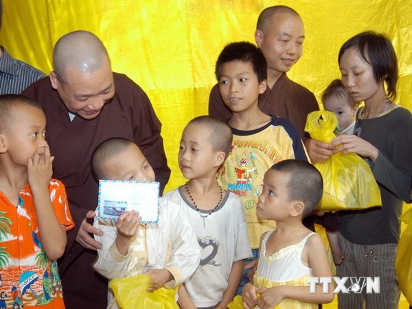 Tặng quà cho trẻ em khó khăn tại lễ ra mắt văn phòng tham vấn hỗ trợ cộng đồng tại Chùa Bồ Đề. (Ảnh: Dương Ngọc/TTXVN)