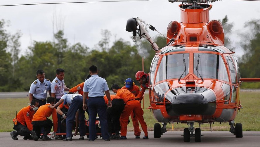 Các nhân viên cứu hộ Indonesia chuyển thi thể một nạn nhân máy bay QZ8501. Ảnh: AFP/TTXVN.
