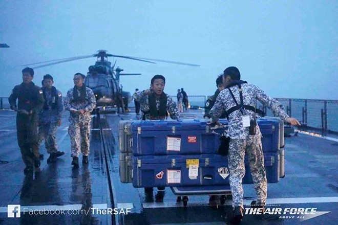 Thủy thủ trên tàu RSS Persistence của Singapore đưa thiết bị lặn tự động xuống nước để tìm máy bay QZ8501. Ảnh: Twitter
