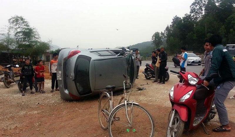 Hiện trường vụ tai nạn. Chiếc xe con sau khi va chạm bị hất văng ra lề đường và lộn vòng.