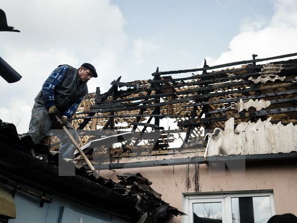 Người dân địa phương sửa chữa căn nhà bị đổ nát trong xung đột tại Donetsk. Nguồn: AFP/TTXVN